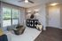 Chic living room with modern decor, featuring large window with geometric curtains, elegant sideboard, and stylish glass coffee table on plush rug.