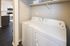 Chic apartment laundry area featuring modern washer and dryer with adjacent stylish kitchen visible.