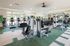 Bright and inviting fitness center with modern exercise equipment, featuring treadmills, weight machines, and a mirrored wall for a sleek, open feel.