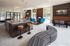 Chic open-concept lounge featuring modern kitchen, vibrant teal seating, and large windows for natural light.