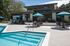 Luxurious modern patio featuring a sparkling swimming pool, stylish lounge chairs, and vibrant umbrellas, perfect for relaxation and entertaining.