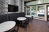 Chic lounge area with elegant marble-top tables, modern chairs, and a vibrant pool view through large windows, perfect for relaxation.