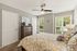 Bright and cozy bedroom with large windows, stylish decor, and a comfortable bed in a serene ambiance.