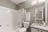 Modern bathroom with sleek granite countertop, stylish fixtures, and a relaxing bathtub area.