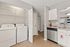 Sleek apartment interior showcasing a modern kitchen with granite countertops, stainless steel dishwasher, and in-unit laundry area.
