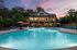 exterior pool and clubhouse two-story building at dusk