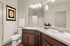 furnished bathroom with two sinks and toilet in apartment home
