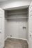 Contemporary utility closet with wire shelving and hardwood floors, ready for customizable storage solutions.