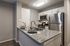 Modern kitchen with elegant granite countertops, stainless steel appliances, and stylish place settings.