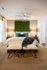 Luxurious bedroom with elegant green accents, featuring a plush bed, stylish nightstands, and cozy lighting for a sophisticated ambiance.