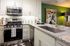 Elegant modern kitchen featuring stainless steel appliances, granite countertops, and chic decor in a cozy space.