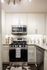 Modern kitchen with sleek stainless steel appliances, elegant white cabinetry, and stylish granite countertops.