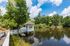 Charming lakeside view with a picturesque gazebo and serene woodland backdrop, perfect for relaxation.
