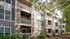 Charming modern apartment building with elegant balconies surrounded by lush greenery, perfect for tranquil living.