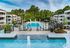 Luxurious apartment complex with a stunning outdoor pool area, surrounded by lush greenery and elegant balconies for a serene living experience.