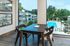 Chic dining area with modern furniture overlooking a stunning pool and lush greenery through expansive windows.