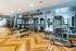 Luxurious gym facility with state-of-the-art fitness equipment and elegant hardwood flooring.