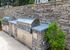 Elegant outdoor kitchen with dual stainless steel grills and stone backsplash, perfect for sophisticated entertaining.