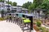 Chic outdoor seating area overlooking a pristine pool, perfect for relaxation and entertainment in a lush residential complex.