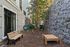 Cozy outdoor community space featuring a bench, play equipment, and lush greenery.
