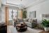 Bright and stylish living room with a modern gray sectional sofa, chic chandelier, and tasteful decor.