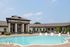 Elegant residential building with a spacious, inviting swimming pool area surrounded by lush greenery.