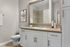 Modern bathroom with sleek vanity, large mirror, and stylish decor elements.