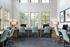 Bright and spacious office space with multiple workstations, large windows, and modern chairs.