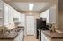 Modern kitchen with sleek countertops, white cabinetry, and stainless steel appliances in a bright, inviting space.