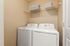 Modern laundry room with sleek washer and dryer, built-in shelving, and neutral decor.