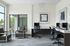 Updated business center with sleek computers, elegant leather chairs, and large windows for natural light.