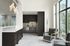 Chic clubhouse kitchen with sleek cabinetry, artistic lighting, and cozy seating area with large windows.