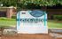 Charming Anson at the Lakes apartment homes entrance sign surrounded by lush greenery and natural stone accents.