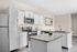 Modern kitchen with elegant white cabinetry, sleek stainless steel appliances, and stylish granite countertops.