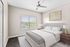 Bright and airy bedroom featuring a cozy bed, elegant side tables, and a ceiling fan, illuminated by natural light through a large window.