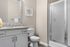 Chic bathroom with elegant granite countertop, modern shower, and vibrant wall art, perfect for relaxing decor.