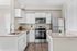 Modern kitchen with sleek stainless steel appliances, elegant granite countertops, and stylish white cabinetry.