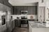 Modern kitchen with sleek dark cabinets, stainless steel appliances, and granite countertops.
