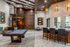Stylish recreation room with a pool table, spiral staircase, and modern lighting features.