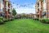 Charming apartment exterior with well-maintained gardens and string lights overhead.