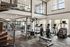 Bright, spacious fitness center with cardio machines, weightlifting equipment, and a spiral staircase.