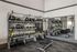 Modern fitness room with TRX equipment, kettlebells, and gym mirrors, designed for versatile workouts.