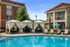 Luxurious outdoor pool area with elegant cabanas, comfortable lounge chairs, and modern apartment backdrop.