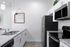 Contemporary kitchen with granite countertops, stainless steel appliances, and clean white cabinetry.