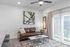 Bright and stylish living room featuring a leather sofa, abstract artwork, and a sleek coffee table.
