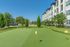 Beautiful outdoor putting green beside a modern apartment building with lush landscaping.
