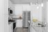 Contemporary kitchen with white cabinetry, stainless steel appliances, and granite countertops.