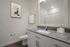 Chic bathroom featuring a granite countertop, modern fixtures, and stylish wall art.