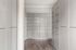 Elegant storage space featuring sleek modern cabinetry with ample shelving, complemented by stylish wood flooring.