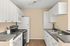 Chic and modern kitchen with sleek countertops, white cabinetry, and stainless steel appliances, perfect for culinary enthusiasts.